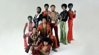 Photo of the band Earth, Wind & Fire posing in stylish outfits, showcasing their iconic 1970s aesthetic.