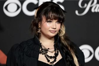 British singer-songwriter Lola Young at a red carpet event, featuring a stylish outfit and distinctive jewelry.