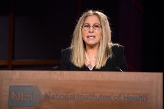 Barbra Streisand speaking at a podium during an event at the National Institutes of Health.