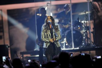 Alanis Morissette performing on stage during a live concert.