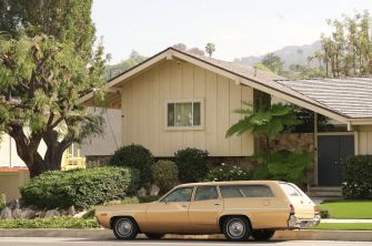 The exterior of the house made famous by the television sitcom "The Brady Bunch," with a vintage car parked in front.