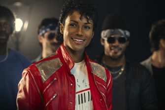 A scene from the film *Michael*, depicting a character in a red jacket resembling the iconic style associated with Michael Jackson.