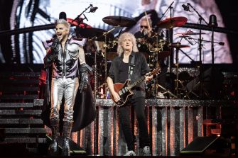 Queen performing with Adam Lambert on stage, showcasing their musical collaboration.