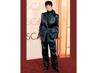 Diane Warren posing in a blue suit at the 2026 Academy Awards.
