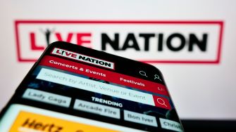 A smartphone displaying the Live Nation app, featuring sections for concerts, events, and festivals, with the Live Nation logo in the background.