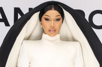 Cardi B posing in a striking fashion ensemble at a public event.