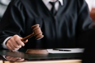 A judge holding a gavel in a courtroom setting.