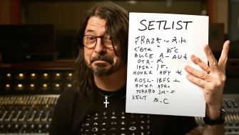 Dave Grohl holding a paper with a setlist in a recording studio setting.