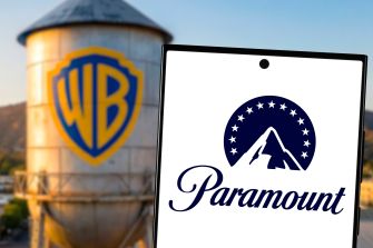 Logos of Warner Bros. and Paramount with a water tower featuring the WB logo in the background.