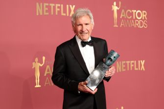 Harrison Ford holding the SAG-AFTRA Life Achievement Award during the annual SAG Awards ceremony, dressed in a formal black suit and bowtie.