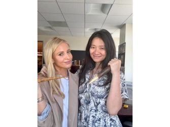Sarah Michelle Gellar and Chloé Zhao posing together, holding props related to their project.