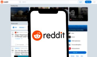 Image of a smartphone displaying the Reddit logo on its screen with a blurred background of the Reddit homepage.