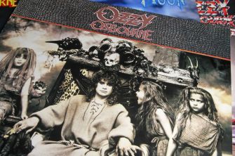Image of Ozzy Osbourne sitting on a throne adorned with skulls and surrounded by figures, representing a dramatic moment related to his career.