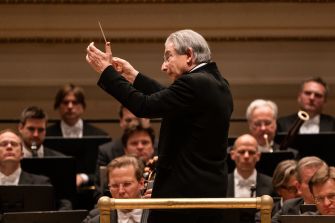 Conductor Michael Tilson Thomas leads an orchestra during a performance, showcasing his role in classical music.
