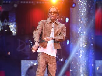 Soulja Boy performing on stage in a stylish outfit, celebrating his new streaming deal with Kick.