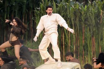 Bad Bunny performing during the Super Bowl Halftime Show, featuring dancers and a vibrant outdoor setting.