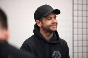 Jack Osbourne participating in a discussion, wearing a black cap and hoodie.