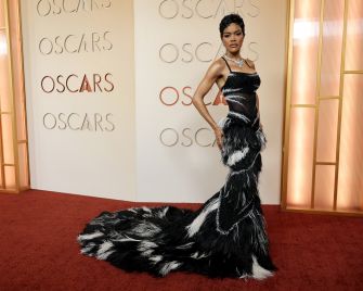 Teyana Taylor poses on the red carpet at the Oscars wearing a dramatic black and white gown.
