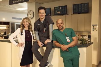 Cast members of the medical comedy series Scrubs at the nurses' station in a hospital setting.