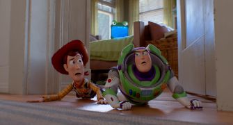 Woody and Buzz Lightyear crawling on the floor in a scene from "Toy Story 5."