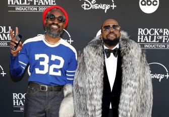Two members of the hip-hop duo Outkast posing on the red carpet at a public event.