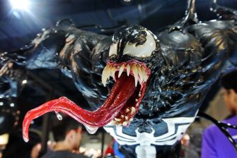 Close-up of a Venom figure featuring distinctive black symbiote design, elongated tongue, and sharp teeth.