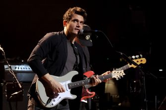 A musician performing on stage with a guitar.