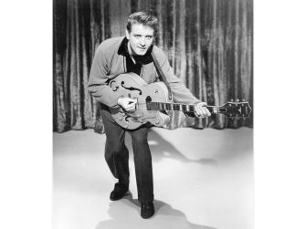 Eddie Cochran posing with a guitar, showcasing his influence on early rock music.