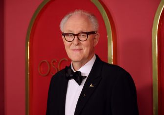 John Lithgow poses in formal attire at an event.