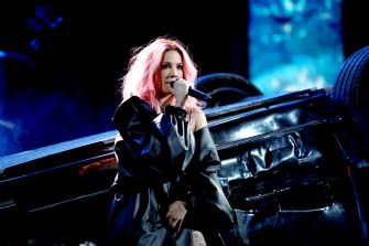 Halsey performing live with a dramatic backdrop during a concert.