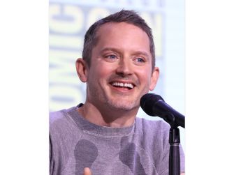 Elijah Wood smiling while speaking at a public event.