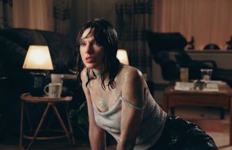 A scene from Taylor Swift's 'Opalite' music video featuring a character in a casual setting with a wet appearance.