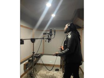 Talay Riley recording music in a studio setting.