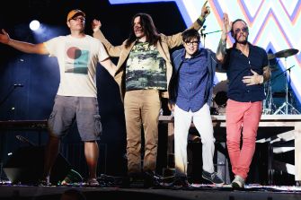 Weezer band members performing on stage during a concert.