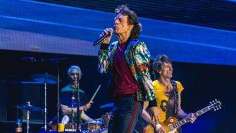 The Rolling Stones performing live, featuring Mick Jagger singing and playing with band members on stage.