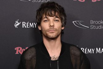 Louis Tomlinson at an event, wearing a black outfit.