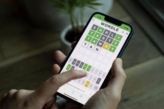 A person playing the Wordle game on a smartphone, showing their guesses on the screen.