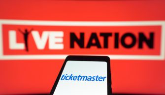Logo of Ticketmaster displayed on a mobile phone in front of a Live Nation background.