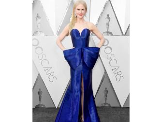 Nicole Kidman on the red carpet wearing a blue gown at an awards ceremony.