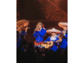 Karol G performing onstage with mariachi musicians during her Coachella set, celebrating Latin music and announcing her upcoming tour.