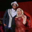 T.I. and Tiny Harris posing at an event, both dressed in formal attire against a red backdrop. T.I. and Tiny Harris posing at an event, both dressed in formal attire against a red backdrop.