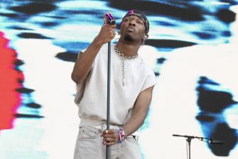 Musician D4vd performing on stage with a microphone.