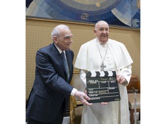 Martin Scorsese and Pope Francis pose with a clapperboard for the film "Aldeas, the Final Dream of Pope Francis."