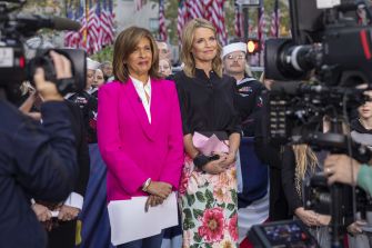 Savannah Guthrie and Hoda Kotb seen during a broadcast, with a backdrop of flags and a crowd.