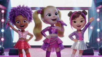Three animated characters performing on stage, dressed in colorful, glittery outfits.