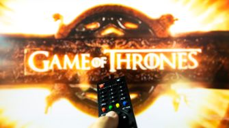 Remote control in front of a "Game of Thrones" logo on a screen.