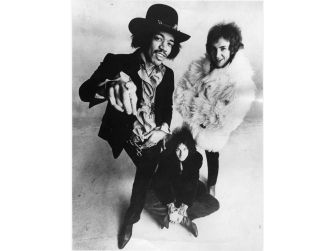 A photograph featuring Jimi Hendrix and two bandmates posing together.
