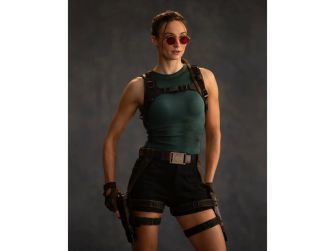 Sophie Turner as Lara Croft in the upcoming Tomb Raider television series, wearing an action outfit with sunglasses and accessories.