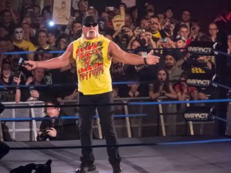 Hulk Hogan performing in a wrestling ring with a cheering crowd during an event.