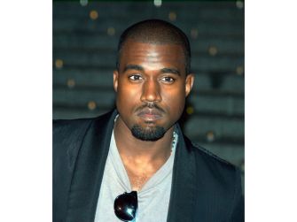 Kanye West posing for a photo at an event.
